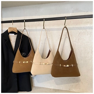 Detail of suede crescent tote bags with vintage metal locks and decorative straps