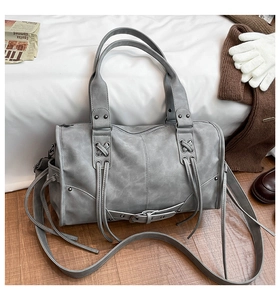 Detailed view of grey wasteland style handbag with metal studs and leather lace-up details