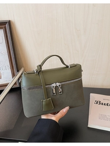Detail of vintage dark green leather tote with top handle and double zipper closure