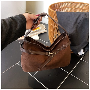 Detail of dark brown suede tote bag with leather straps and vintage gold buckle hardware