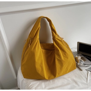 Detail of spacious mustard yellow tote bag with textured fabric and wide shoulder strap