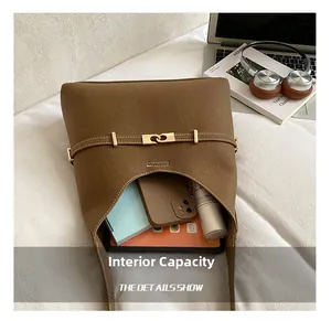 Interior storage space of the brown suede tote bag showing tablet and cosmetics