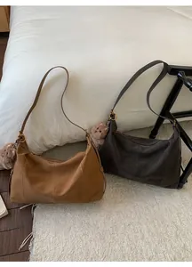 Détail de sacs vintage en cuir marron avec texture mate et pendentifs d'ours