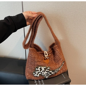 Detail of brown knitted tote bag with leopard print Happy patch and horn buckle closure