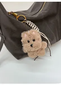 Détail du charm de sac en peluche Yorkshire Terrier avec fermoir doré sur sac à main gris