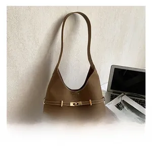 Detail of a brown leather hobo bag featuring a central strap with a gold metal buckle