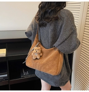 Borsa hobo vintage marrone con ciondolo orsetto in un ambiente accogliente