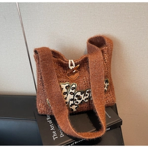 Close-up of brown knit tote with leopard print letters and leather toggle button
