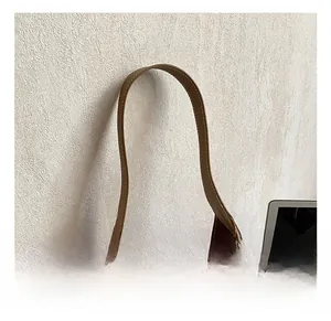Detail showing wide shoulder strap and precision stitching on a camel leather tote bag