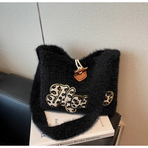 Close-up of black fuzzy tote with leopard print embroidery and toggle horn closure
