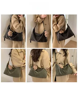 Détails de sacs hobo en daim noir et vert olive avec breloque ours portés par un mannequin