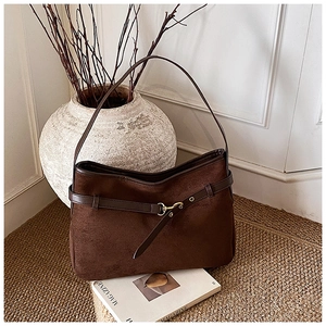 Macro detail of dark brown faux suede bag featuring a vintage gold buckle and strap