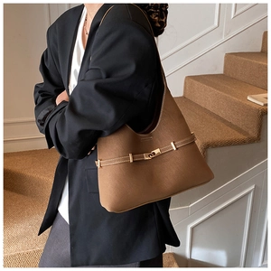 Detailed view of brown retro shoulder bag featuring a golden buckle and matte leather texture