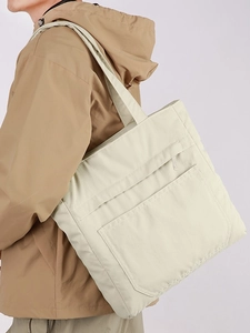 Cream canvas tote bag with large zipper pocket shown as a crossbody shoulder bag