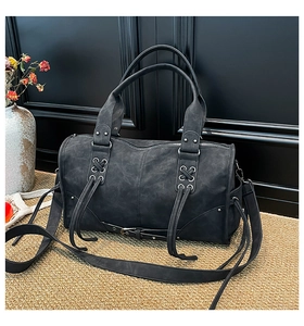 Detail of vintage black cylinder tote with silver eyelets and gothic lace-up design