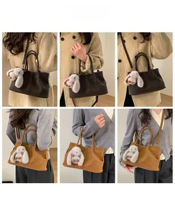 Detail showing vintage matte leather baguette bag with cute plush bunny charm and dual straps