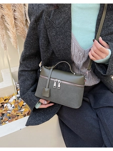 Olive green suede and leather shoulder bag shown on model with chic autumn grey suit