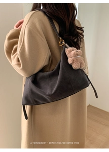 Détail du sac Hobo en daim gris foncé avec un charmant ours en peluche marron et collier de perles