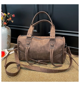 Close-up of vintage brown tote with side lace-up detail and matte faux leather texture