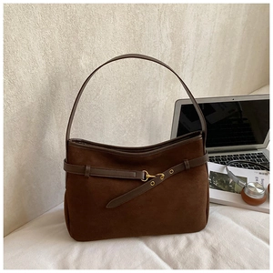 Detail of dark brown matte suede shoulder bag with leather strap and bronze buckle