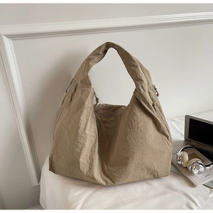 Macro detail of khaki oversized tote bag with pleated nylon fabric and drawstring accents