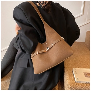 Detail of a brown leather hobo bag with a stylish metal buckle and wide shoulder strap