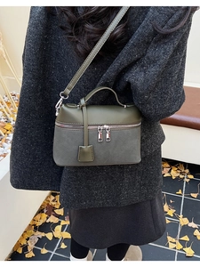 Detail view of olive green and gray box bag with leather straps and silver gingko background