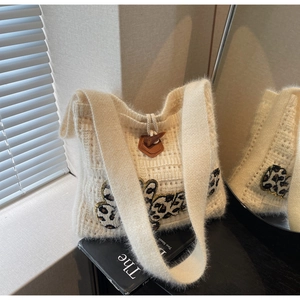 Detail of plush knit tote bag with leopard patch, faux mohair texture and horn buckle