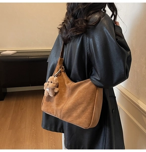 Borsa a tracolla marrone vintage con ciondolo a forma di cane di peluche indossata da modella