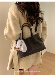Detail of dark grey faux suede tote bag with cute plush bunny charm and dual handles