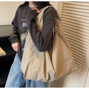 Detail of khaki nylon tote bag with natural pleated texture and wide shoulder strap