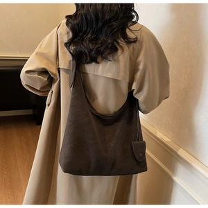 Model view of large chocolate brown tote bag showing its spacious design and matte texture