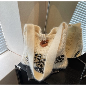 Detail of cream knit shoulder bag with leopard patch and vintage horn button closure