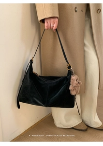 Détail du sac fourre-tout noir minimaliste avec un ourson en peluche et anneau doré