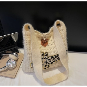Detail of beige knit tote with leopard letter patch and wooden horn toggle button