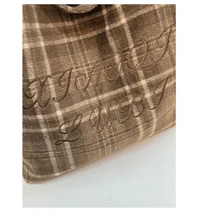 Close-up of retro plaid wool fabric with detailed brand embroidery and soft texture
