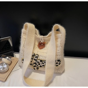 Detail of beige knit tote bag with leopard print patch and toggle button closure