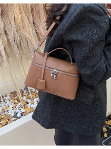 Detail of caramel leather shoulder bag with double zippers and elegant top handle