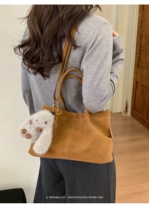 Détail du sac cabas en daim marron avec pendentif lapin en peluche et style rétro chic