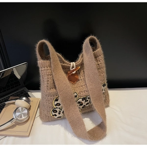 Close-up of khaki knit tote bag with leopard patches and classic toggle horn button