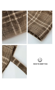Detail of brown plaid fabric tote bag featuring high-quality embroidery and stitching