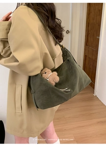 Gros plan du sac hobo en daim vert olive avec charm ours en peluche et boucle en métal