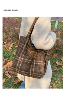 Close-up of brown plaid wool tote bag featuring exquisite embroidery and warm texture