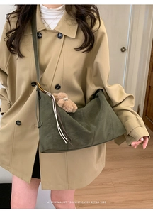Détail d'un sac cabas vintage en cuir mat vert foncé avec une peluche d'ours décorative