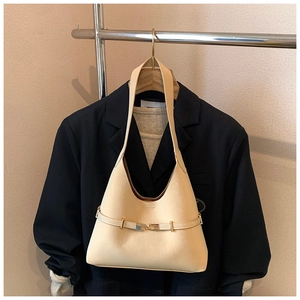 Minimalist beige matte leather tote bag styled on a wood hanger with a dark blazer