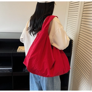 Large red canvas tote bag shown on model highlighting spacious interior and soft fabric
