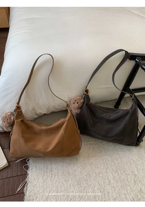 Sacs à bandoulière rétro minimalistes en cuir marron et café foncé sur une literie blanche