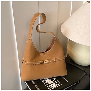 Detailed macro view of caramel leather hobo bag showing white contrast stitching and gold buckle