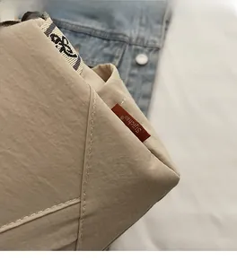 Detail of nylon square bag with beige fabric texture and woven jacquard shoulder strap