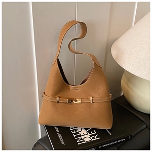 Detail of tan pebble leather hobo bag featuring gold metal buckle and contrast stitching